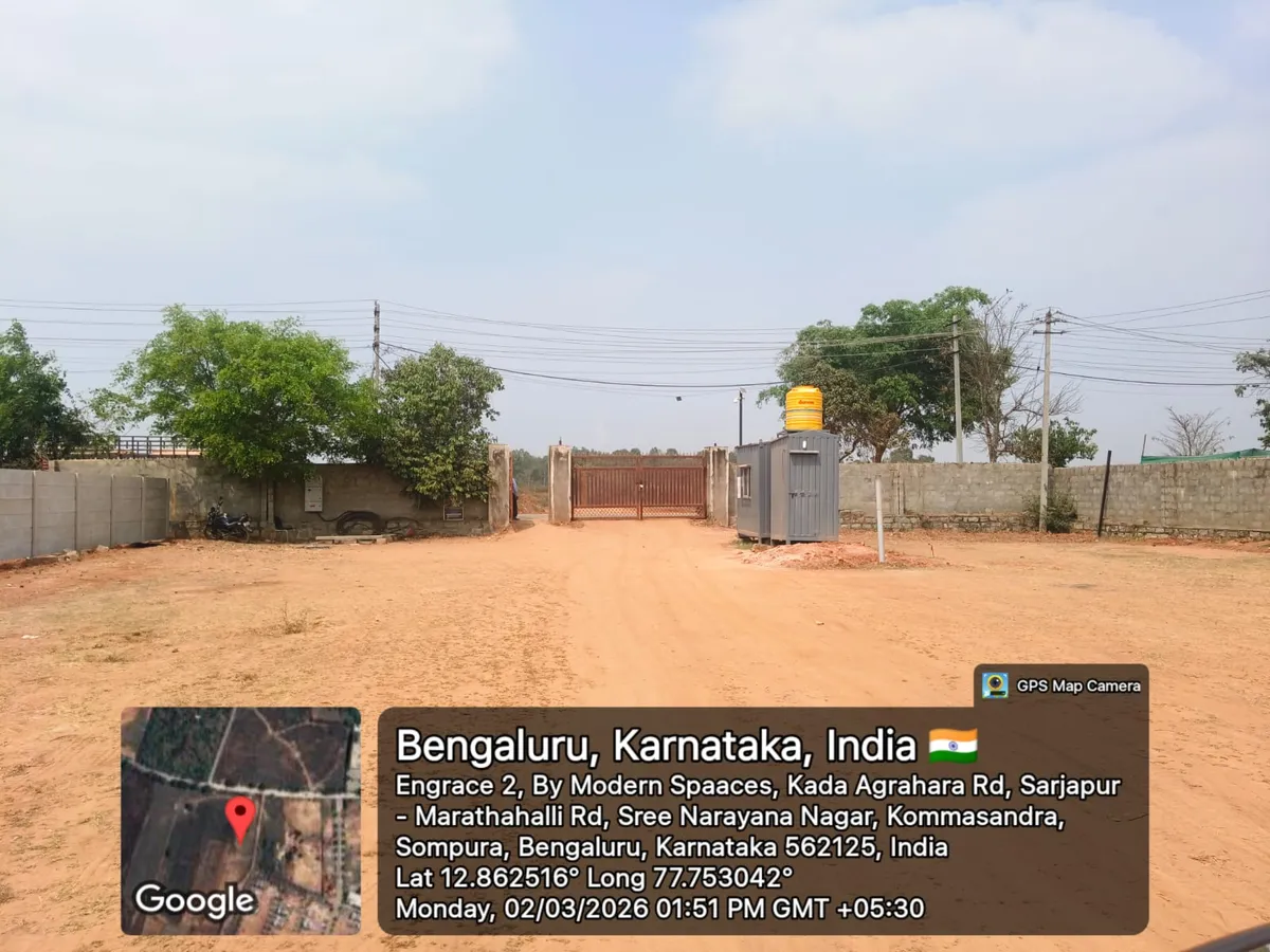 Godrej Regent Park site entrance with security cabin and water tank on the cleared, walled project land at Kada Agrahara, Sarjapur Road — March 2026 (Karnataka RERA filing)