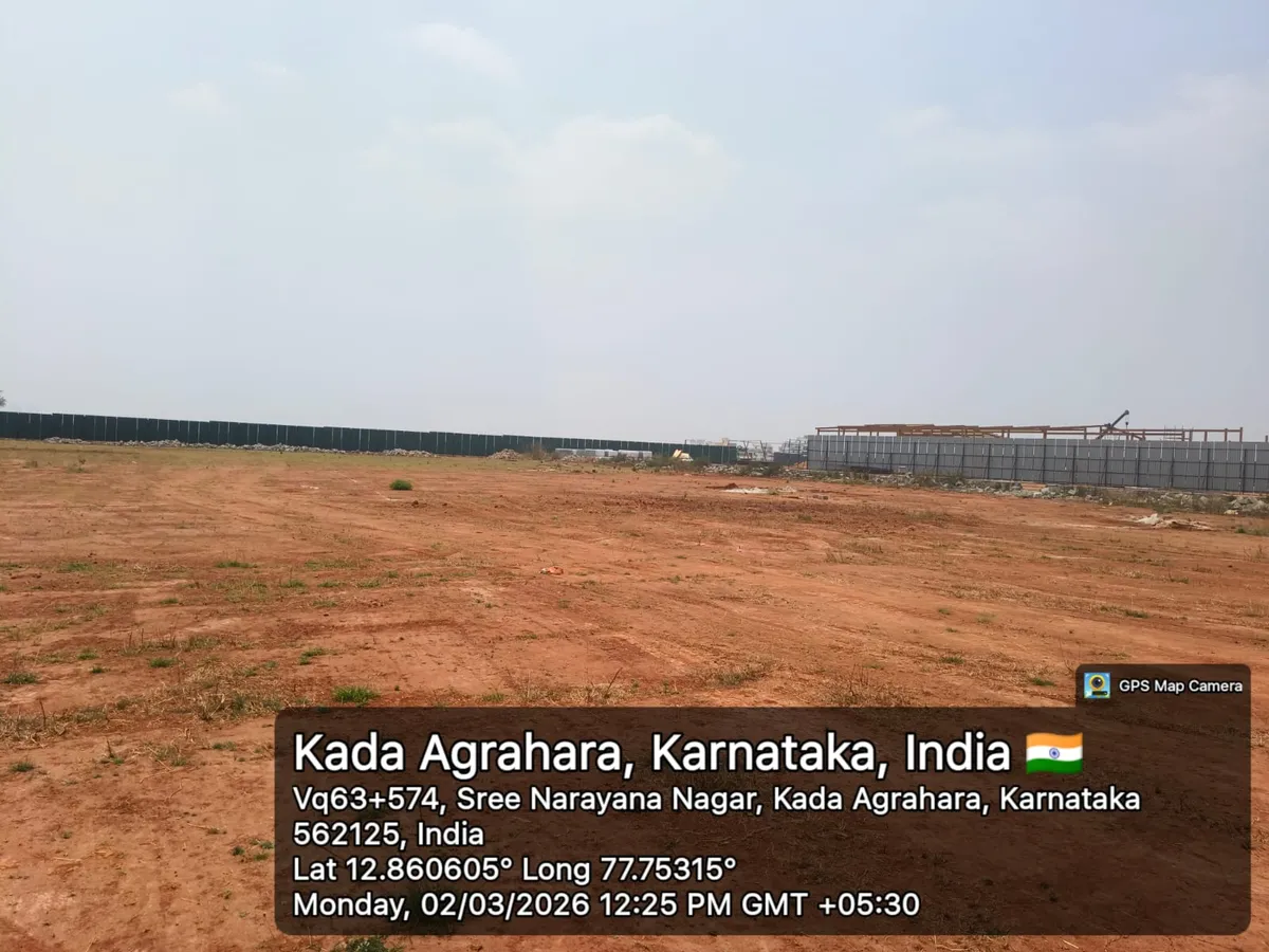 Godrej Regent Park cleared land with green site hoarding and a steel structure under erection in the background, Kada Agrahara — March 2026 (Karnataka RERA filing)