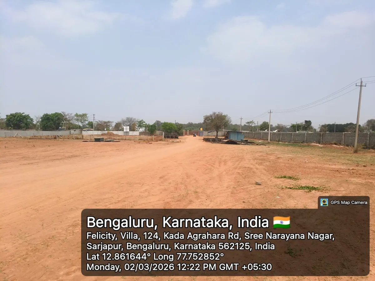 Godrej Regent Park cleared land with perimeter compound wall and internal access track leading to the site gate, Kada Agrahara — March 2026 (Karnataka RERA filing)