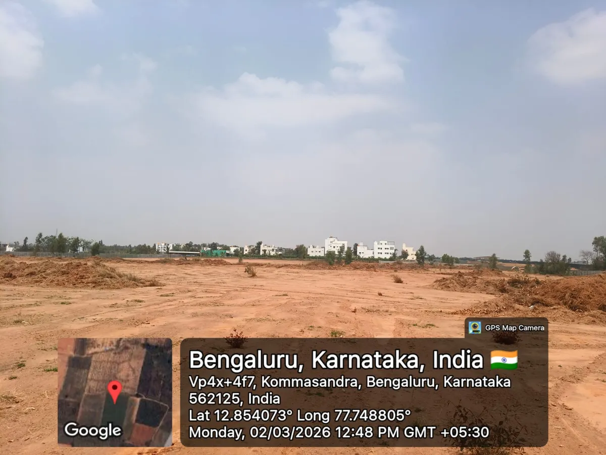 Godrej Regent Park cleared land with a completed residential cluster along the far boundary, Kada Agrahara — March 2026 (Karnataka RERA filing)